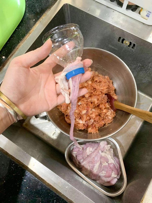 Nhồi nguyên liệu vào lòng non là bước quan trọng trong cách làm dồi sụn